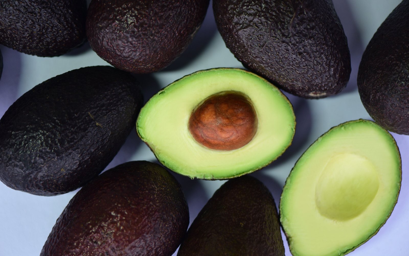 Whole and halved avocados showing different skin textures
