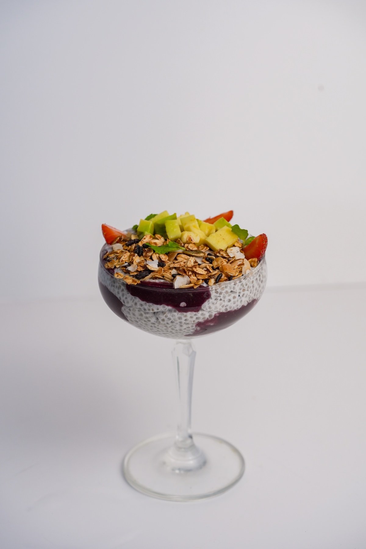 Chia pudding dessert with granola and avocado cubes