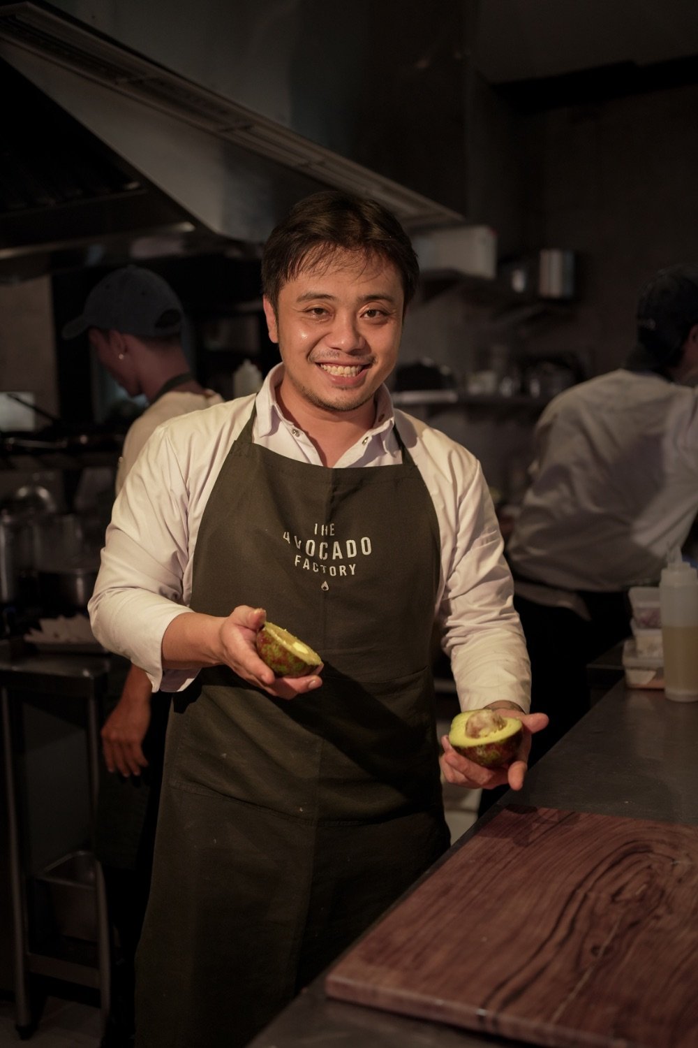 The founder in the kitchen, holding a freshly cut avocado