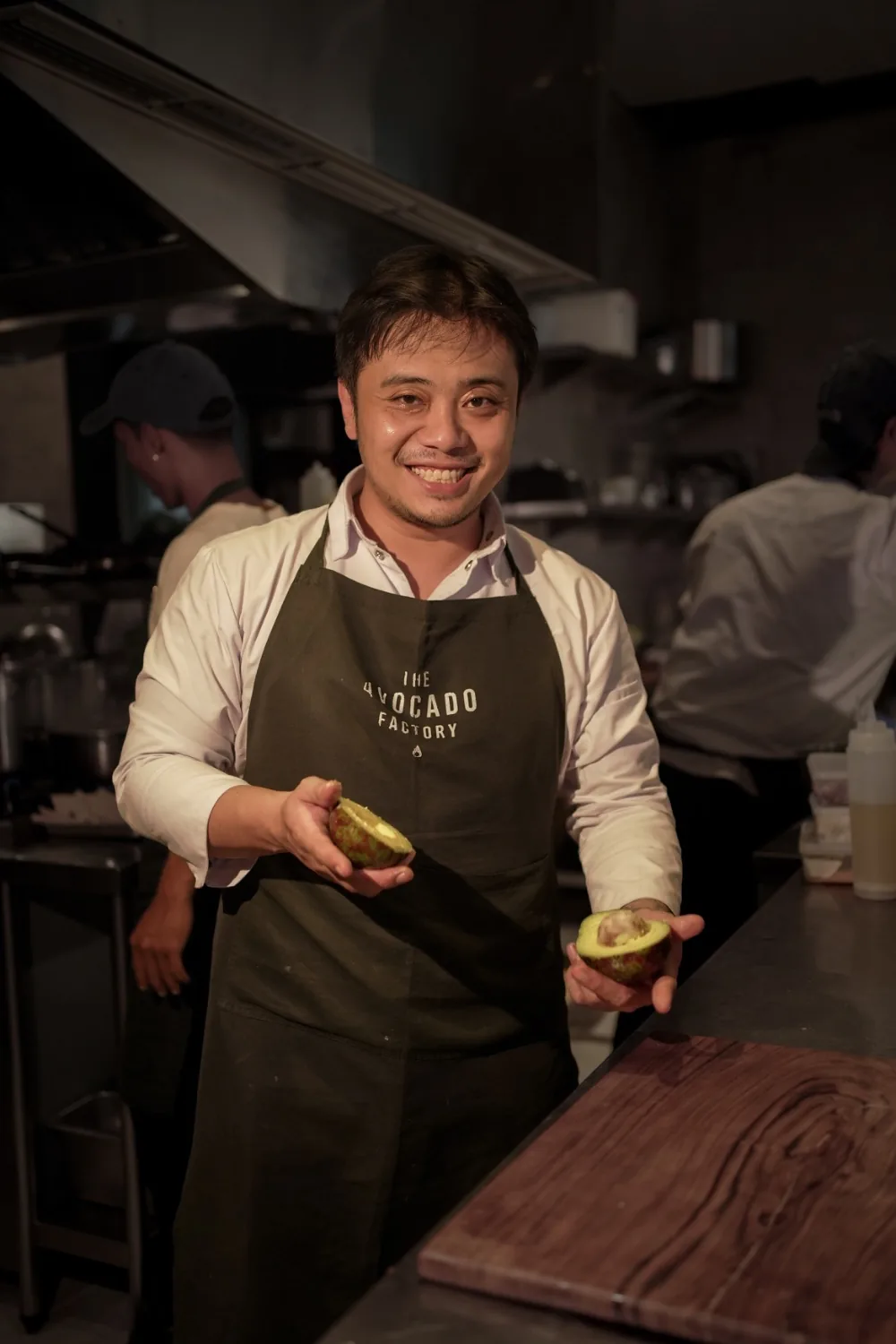 The founder in the kitchen, holding a freshly cut avocado